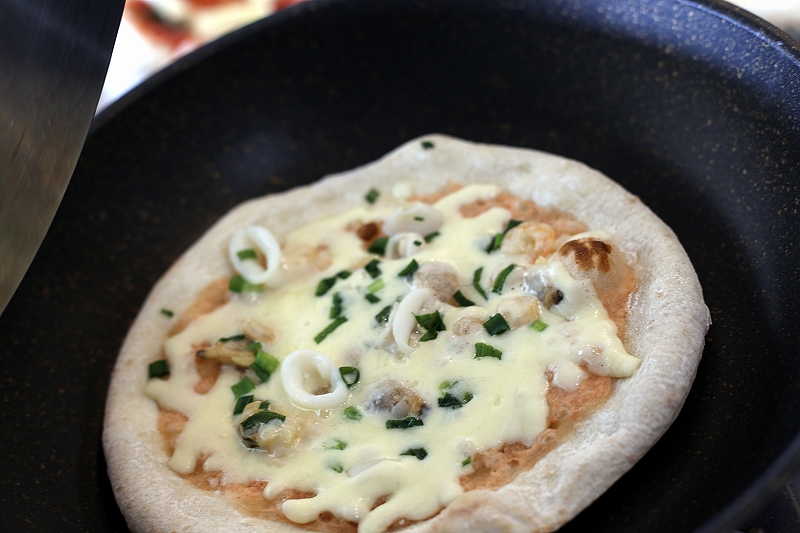 フライパンで加熱されるフォンターナのピザ